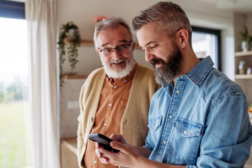 Older and younger man looking at smartphone